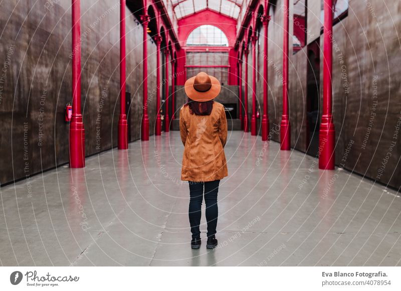 Rückenansicht der jungen kaukasischen Frau im Freien über roten Säulen Gebäude. Reisen Konzept Rückansicht Großstadt Architektur urban reisen hübsch Dame heiter