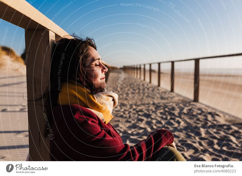 junge kaukasische Frau mit geschlossenen Augen entspannt am Strand bei Sonnenuntergang. Urlaub und Entspannung Konzept sich[Akk] entspannen Kaukasier Feiertage