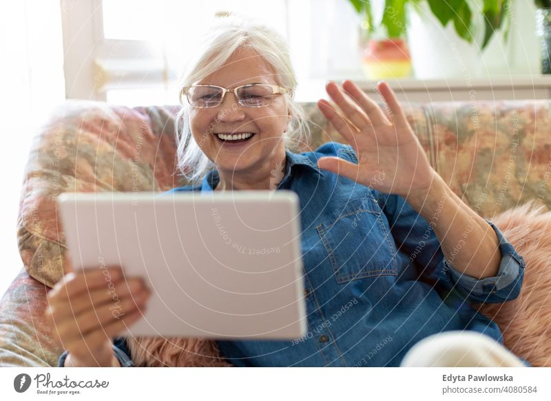 Ältere Frau verwendet digitales Tablet zu Hause Lächeln Glück genießend Positivität Vitalität Freude Selbstvertrauen Menschen Senior reif lässig Kaukasier älter