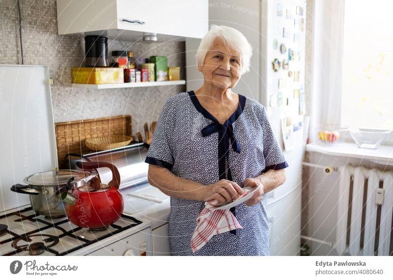 Ältere Frau in ihrer Küche trocknet Geschirr Menschen Senior reif lässig Kaukasier älter heimwärts Haus alt Alterung häusliches Leben Großmutter Rentnerin