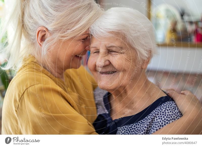 Frau, die ihre ältere Mutter umarmt Lächeln Glück genießend Positivität Vitalität Freude Selbstvertrauen Menschen Senior reif lässig Kaukasier heimwärts Haus