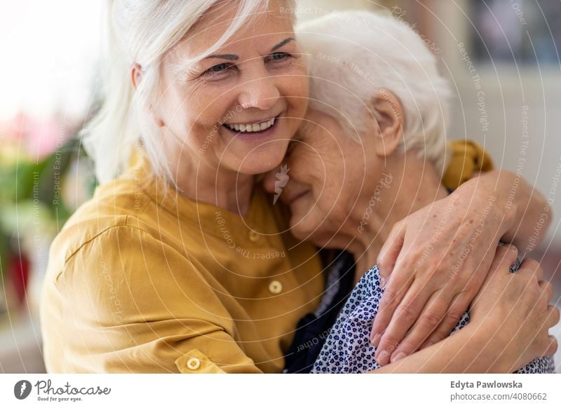 Frau, die ihre ältere Mutter umarmt Lächeln Glück genießend Positivität Vitalität Freude Selbstvertrauen Menschen Senior reif lässig Kaukasier heimwärts Haus