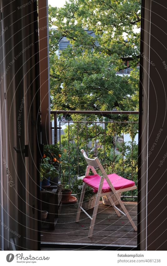 Stuhl mit pinkem Kissen auf einem Balkon und großem Baum im Hintergrund grün Idylle Häusliches Leben Erholung ruhig Sommer Klappstuhl Wohnung Terrasse Möbel