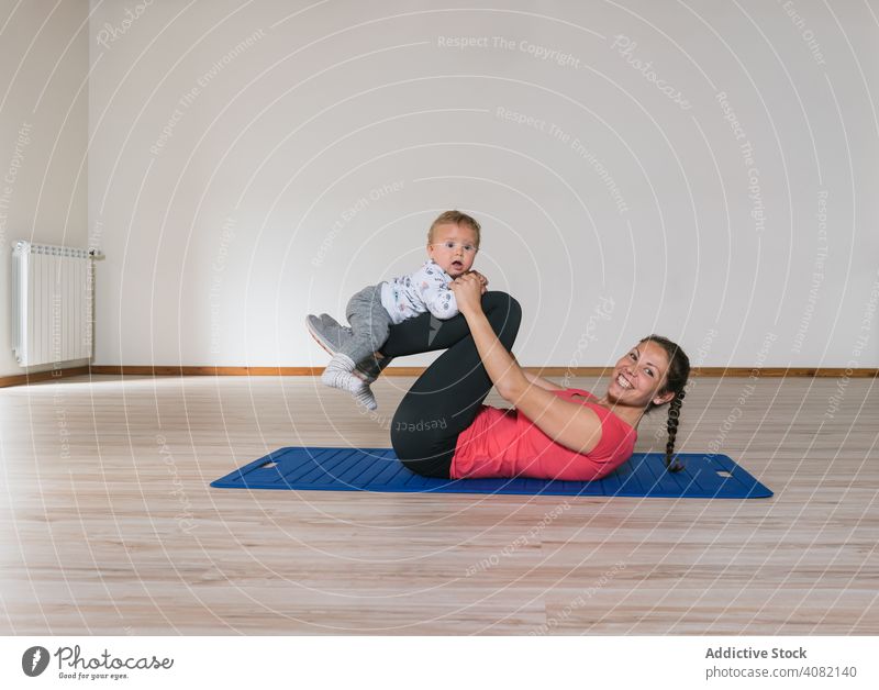Mutter trainiert mit Baby im Fitnessstudio Übung Training Lügen Stock Bauchmuskeln modern Lifestyle Frau Kinder Kleinkinder Glück Lächeln heiter Freude