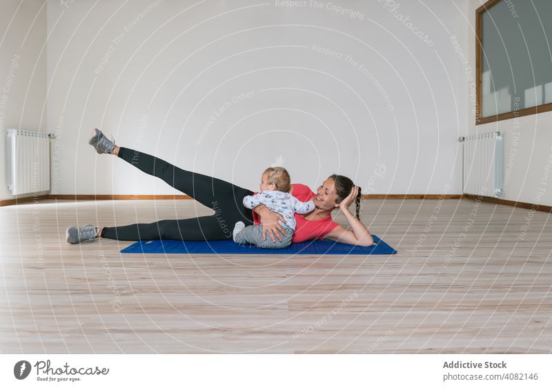 Mutter trainiert mit Baby im Fitnessstudio Übung Training Lügen Stock Bauchmuskeln modern Lifestyle Frau Kinder Kleinkinder Glück Lächeln heiter Freude