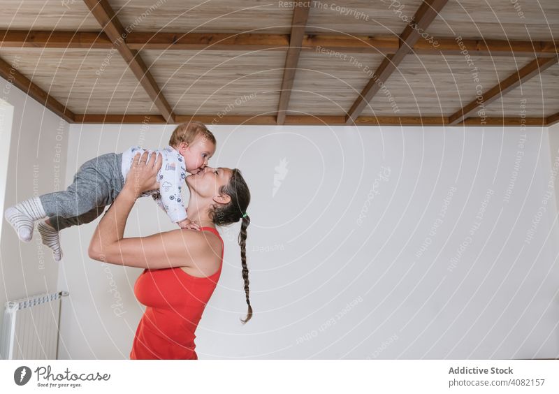 Frau küsst Baby in der Turnhalle Mutter Kuss Heben Fitnessstudio Training modern Lifestyle Kind Säugling Sportbekleidung Freizeit Gesundheit Wellness