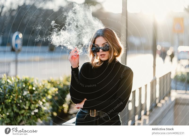 Stilvolle Frau Beleuchtung Zigarette in der Nähe von U-Bahn-Station Rauchen Straße sonnig tagsüber Großstadt urban unterirdisch Eingang jung Lifestyle Freizeit