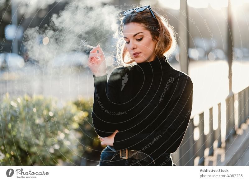 Hübsche Frau Rauchen auf der Straße Zigarette ausatmend Stil sonnig tagsüber Großstadt urban jung Lifestyle Freizeit Dunst ruhen sich[Akk] entspannen Dame