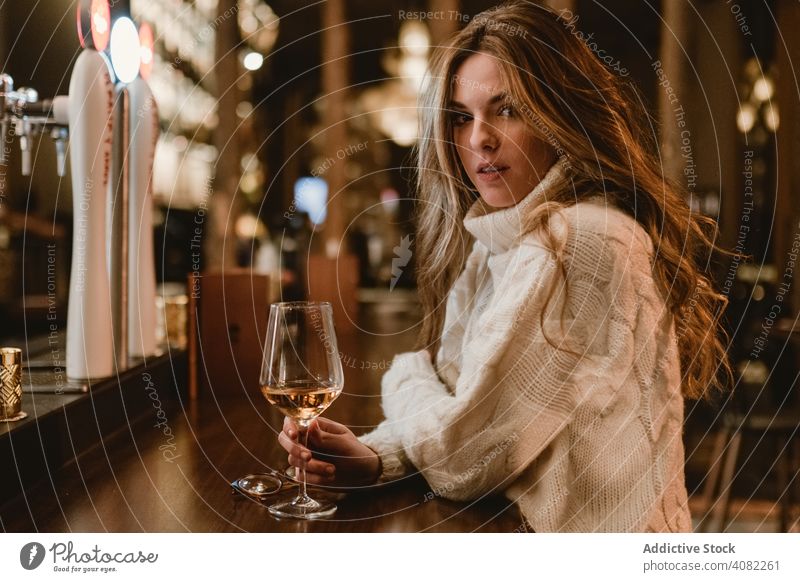 Stilvolle Frau trinkt Wein in einer Bar trinken Stehen Glas Abfertigungsschalter jung elegant Alkohol Schnaps Getränk Kelch Pub Restaurant Lifestyle Freizeit