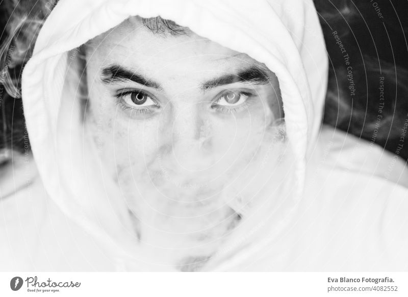 Porträt eines jungen Mannes, der raucht, Studioaufnahme, schwarz-weiß, Nahaufnahme.führte Ring Reflexion in den Augen Kopf dunkel Menschen männlich Zigarette