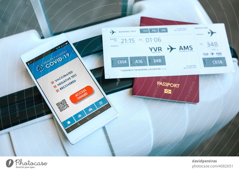 Koffer mit Reisepass, Bordkarte und verweigertem Covid-Pass digitaler Grünpass Zugriff verweigert Handy niemand App Stillleben kein Pass Flughafen Tourismus