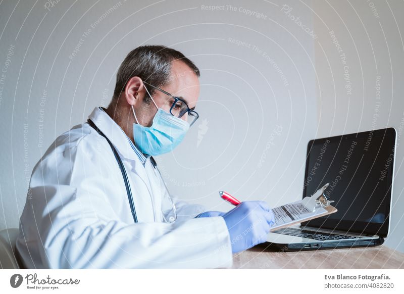 Arzt Mann arbeitet am Laptop. Corona-Virus-Test auf dem Tisch. Covid-19 Konzept Prüfung covid-19 Schutzhandschuhe Schutzmaske Technik & Technologie Analyse
