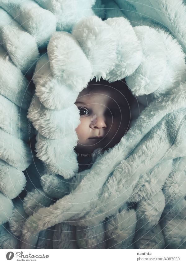 Kleines Baby eingewickelt mit einer warmen grünen Decke Porträt kleines Mädchen künstlerisch Winter gemütlich Vorleger warme Kleidung heimwärts blaue Augen