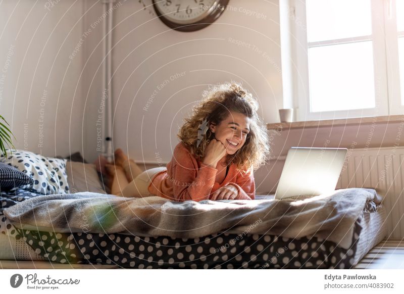Junge Frau arbeitet im Bett zu Hause mit Laptop Bildung Lernen studierend Hausaufgabe Buch E-Learning Technik & Technologie Computer arbeiten Internet online