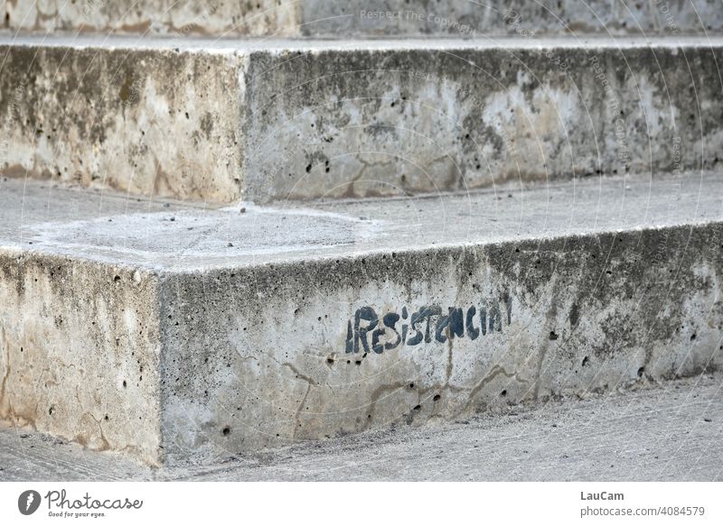 Schwarzer Schriftzug „Resistencia“ auf einer grauen Steintreppe am Velodrom in Berlin Treppe Beton Gedeckte Farben Menschenleer Text Widerstand Schriftzeichen