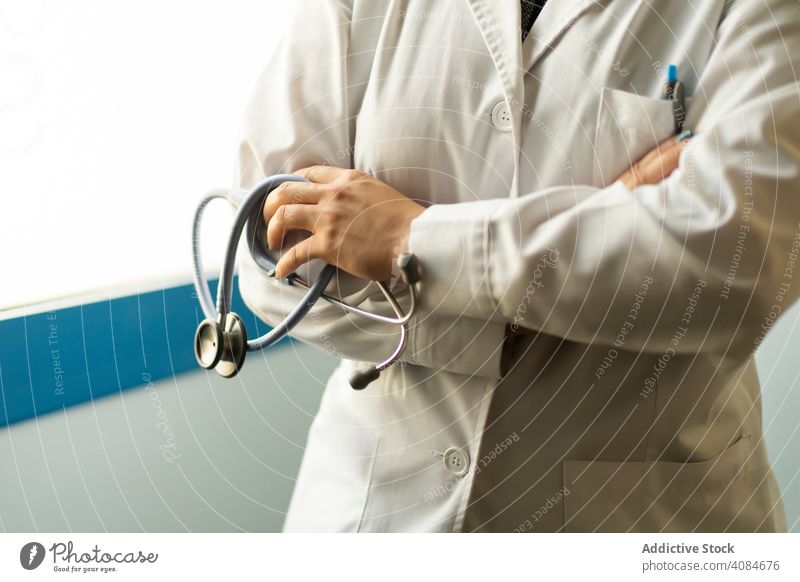 Arzt in Uniform hält Stethoskop medizinisch gekreuzte Hände Raum Krankenhaus Frau professionell Pflege Klinik Spezialist Gesundheitswesen Hygiene schützend