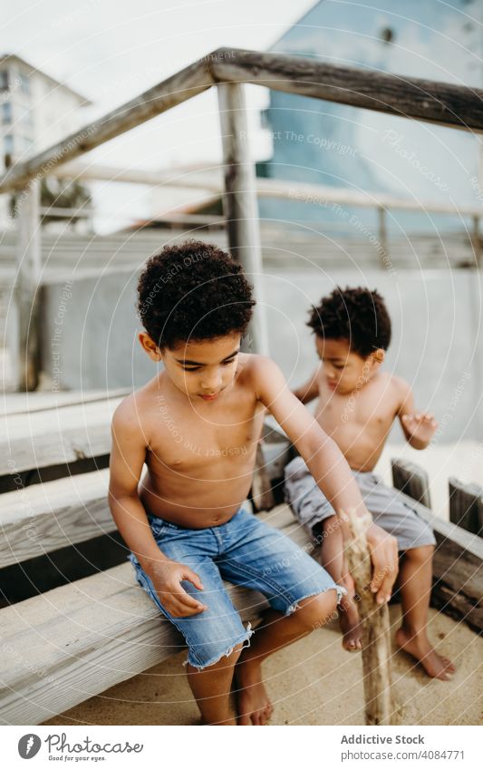 Schwarze Jungen spielen am Strand Brüder MEER Spielen Stöcke Spaß Zusammensein Sommer Wasser ohne Hemd Barfuß Kinder Geschwister Glück Wochenende Lifestyle