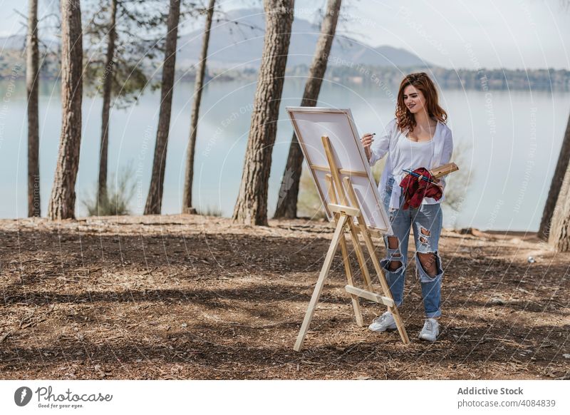 Junge Frau malt auf dem Lande Künstler Natur Malerei See Staffelei Palette Landschaft Sommer Lifestyle Freizeit lässig fokussiert konzentriert Fähigkeit Talent