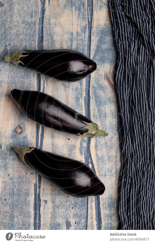 Reife Auberginen auf schäbiger Tischplatte Gewebe reif frisch rustikal Lebensmittel Gesundheit Gemüse Veganer Bestandteil roh Diät Stoff Serviette verwittert