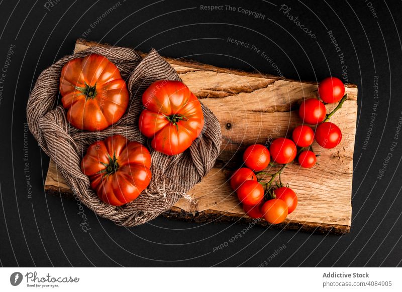 Tomaten und Serviette auf Holzbrett Holzplatte hölzern Bestandteil frisch reif Gemüse Gesundheit Lebensmittel Stoff Gewebe rustikal Veganer saftig geschmackvoll