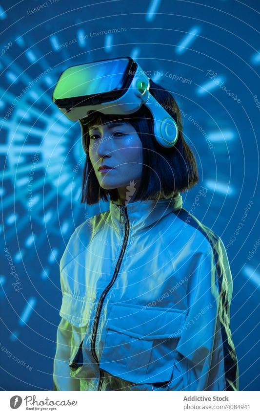 Frau im VR-Headset virtuell Realität Technik & Technologie neonfarbig Licht berührend Gerät digital Innovation jung Person Brille asiatisch modern Entertainment