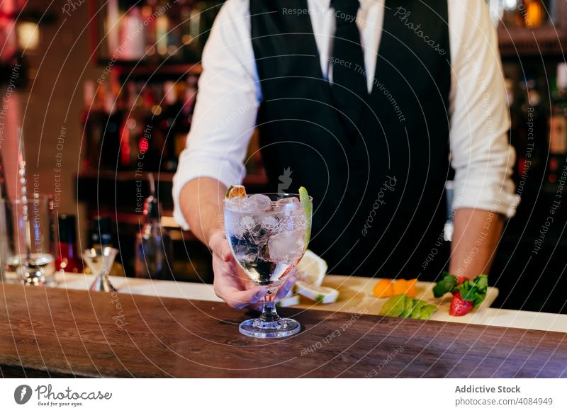 Barkeeper bei der Zubereitung von Getränken Barmann Mann Ananas Glas Kaukasier Gießen Cocktail Krawatte elegant Feier Schüttler Gastfreundschaft Reichtum