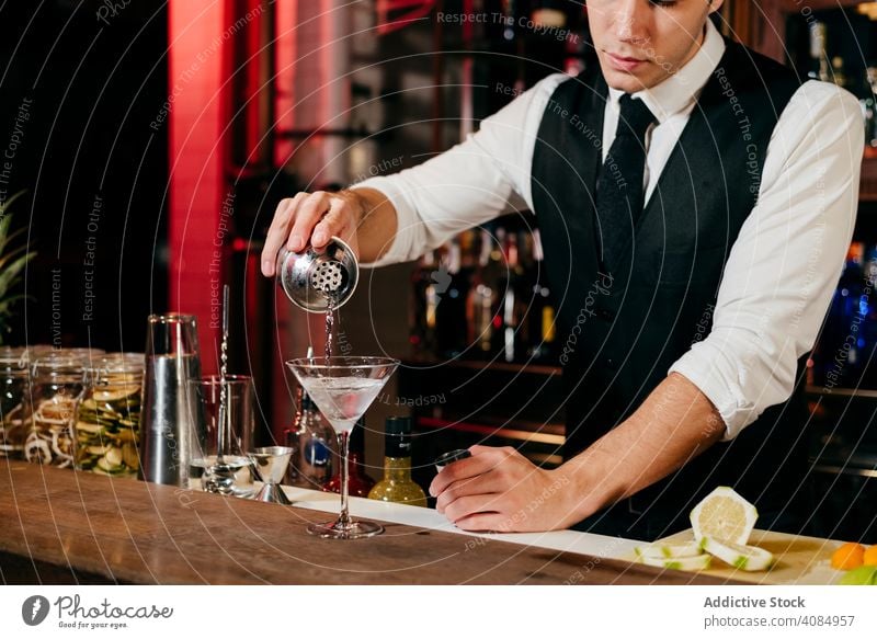 Barkeeper bei der Zubereitung von Getränken Barmann Mann Ananas Glas Kaukasier Gießen Cocktail Krawatte elegant Feier Schüttler Gastfreundschaft Reichtum