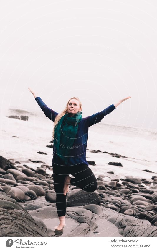 Frau auf Steinen in der Nähe der Meeresküste MEER meditierend hochgezogene Hände Felsen Wasser Hügel schnell platschen Energie jung Natur Yoga Konzentration