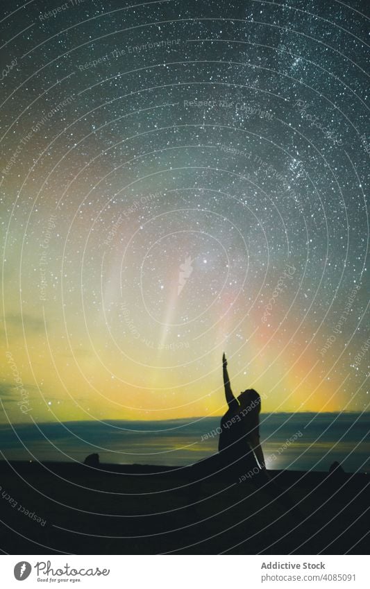 Frau macht Yoga in der Nähe von Himmel in Sterne und Polarlichter in der Nacht Silhouette Land Nordlicht hochgezogene Hände erstaunlich Himmel (Jenseits) Natur