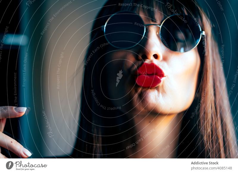 Stilvolle Frau küsst Glas Kuss rot Lippenstift stylisch sinnlich Leidenschaft Erwachsener sexy Sonnenbrille Schirme Accessoire Make-up Sauberkeit durchsichtig