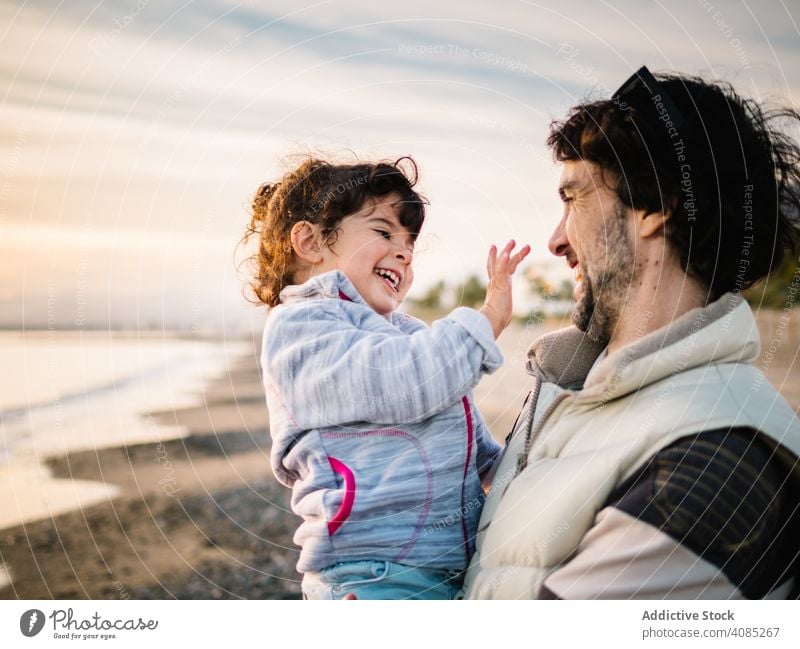 Vater hält kleine Tochter am Strand Umarmung Meer Papa Lifestyle Fröhlichkeit Kind Liebe Tag Mädchen Spaß Kaukasier männlich Beteiligung niedlich Frau Spielen
