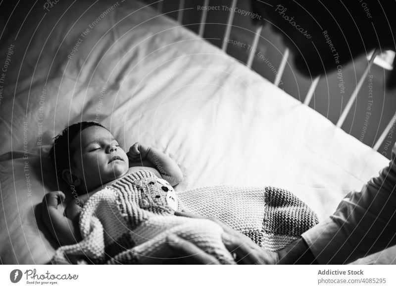 Anonymer Vater, der dem Baby eine gute Nacht wünscht schlafen Babybett Gute Nacht berührend Familie Liebe Angebot Pflege Mann Eltern Kind neugeboren Säugling