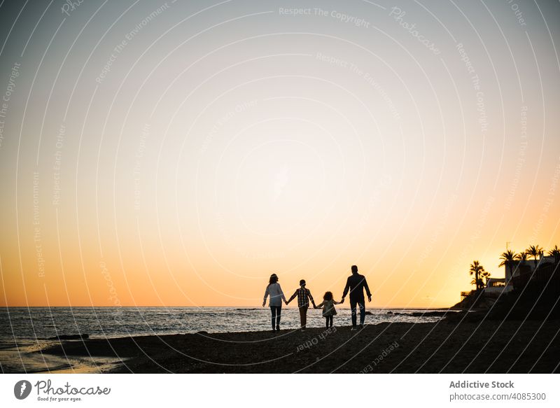Silhouette der Familie hält Hände bei Sonnenuntergang Zusammensein Händchenhalten Strand Urlaub laufen Eltern Sohn MEER Sommer Sand reisen Feiertag tropisch