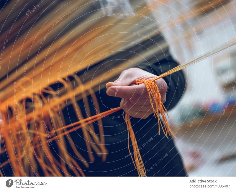Person, die Fäden am Webstuhl hält Weber Beteiligung Gewinde Fabrik Baumwolle industriell Handwerk Textil Weberei Garn Bekleidung Gewebe traditionell Sehne