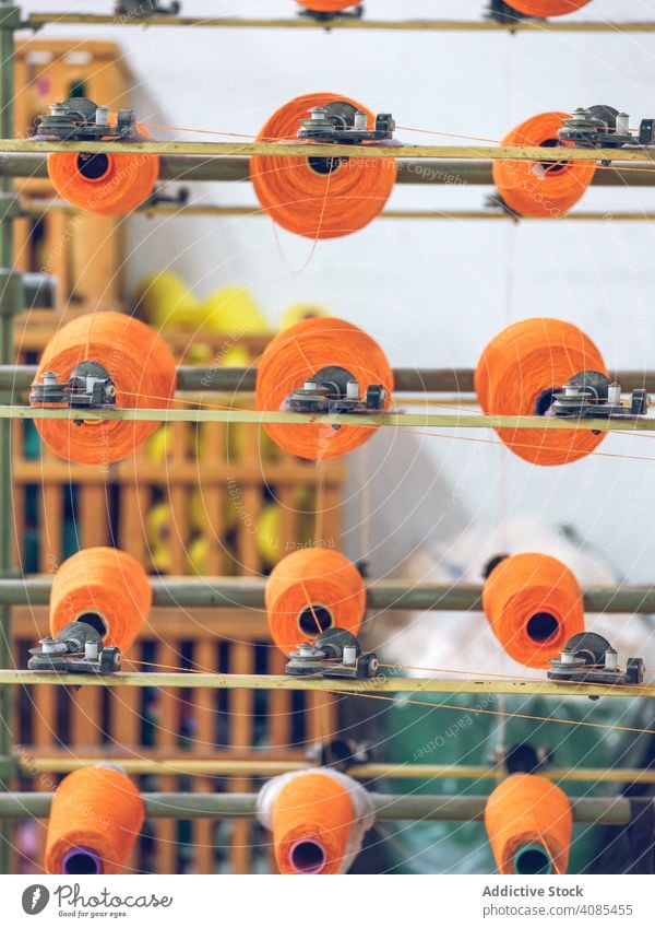 Fadenspulen auf Webstuhl Faser Spulen Industrie Fabrik Sehne Baumwolle Textil Gewebe Maschine Herstellung Schnur Handwerk Garn Stoff orange hell Farbe Material