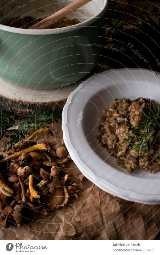 Rosmarin auf Risotto mit Kaninchen und Champignons Reis Pilze Teller Tisch Küche rustikal Speise Abendessen Lebensmittel Fleisch Italienisch Kraut Zweig