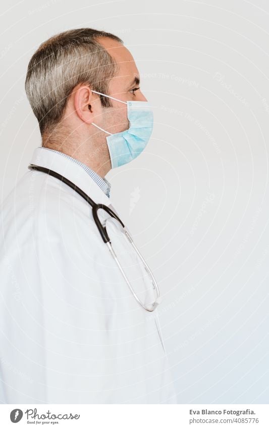 Porträt eines Arztes, der im Haus eine Schutzmaske und Handschuhe trägt. Konzept des Coronavirus Mann professionell Corona-Virus Krankenhaus arbeiten Infektion