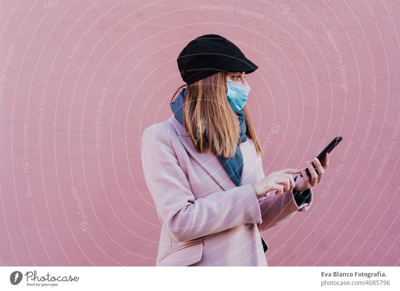Weiße Frau auf der Straße mit Schutzmaske und Mobiltelefon. Coronavirus-Konzept Mundschutz Corona-Virus im Freien Handy Technik & Technologie Internet Kaukasier