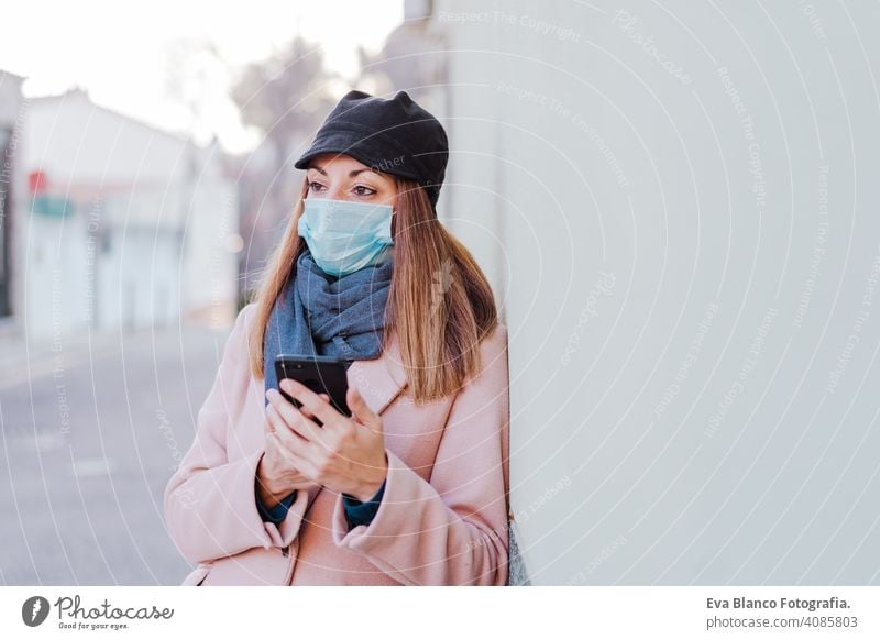 Weiße Frau auf der Straße mit Schutzmaske und Mobiltelefon. Coronavirus-Konzept Mundschutz Corona-Virus im Freien Handy Technik & Technologie Internet Kaukasier