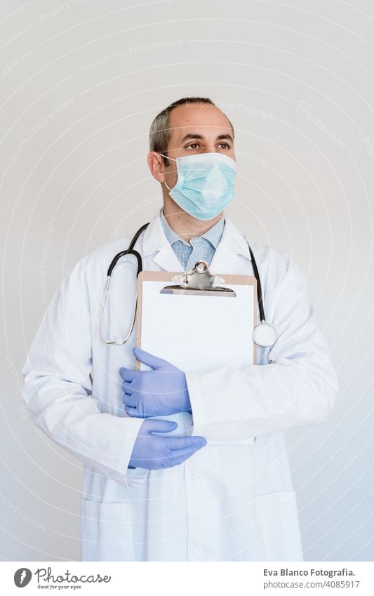 Porträt eines kaukasischen Arztes mit Schutzhandschuhen und Maske. Arbeiten an einem Ordner. Chinesisches Corona-Virus-Konzept. 2019-nCoV Mann professionell