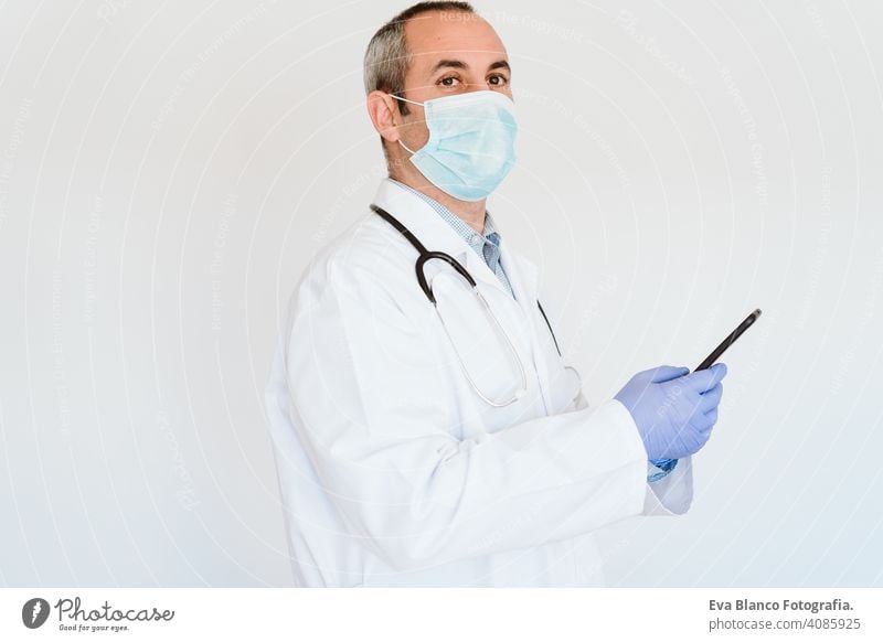 kaukasischen Arzt mit Schutzhandschuhen, Maske und Mobiltelefon. Chinesisches Corona-Virus-Konzept. 2019-nCoV Handy Technik & Technologie benutzend Internet