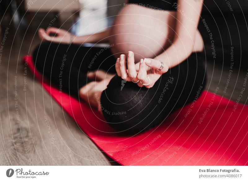 junge schwangere Frau zu Hause übt Yoga Sport. gesunden Lebensstil heimwärts Gesundheit Lifestyle Kaukasier Kindererziehung Schwangerschaftsbeulen Unebenheiten