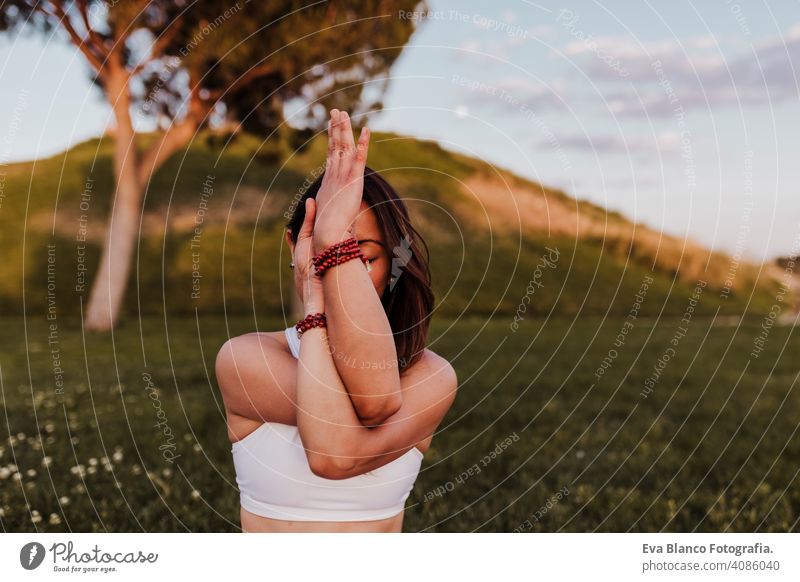 junge schöne asiatische Frau macht Yoga in einem Park bei Sonnenuntergang. Yoga und gesunden Lebensstil Konzept. Sommer Glück Genuss Sport Lifestyle sportlich