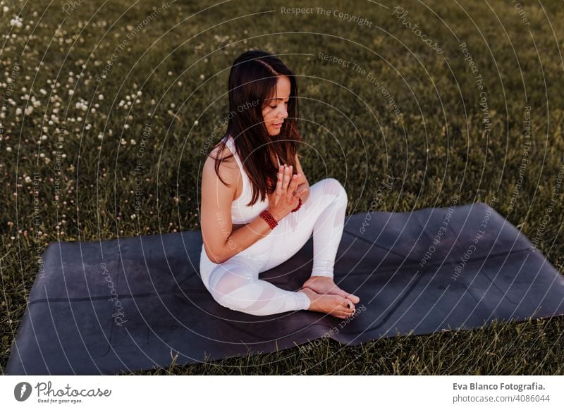 junge schöne asiatische Frau macht Yoga in einem Park bei Sonnenuntergang. Yoga und gesunder Lebensstil Konzept Sommer Glück Genuss Sport Lifestyle sportlich