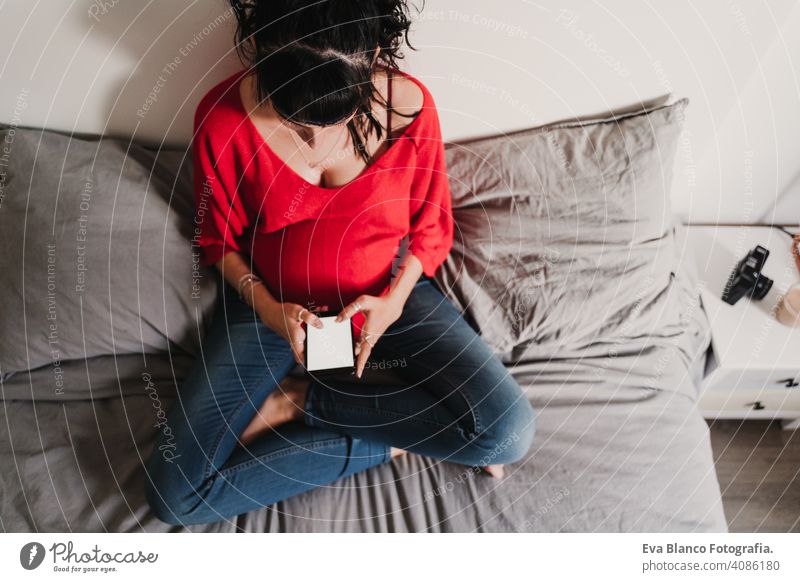 junge schwangere Frau, die zu Hause ein Mobiltelefon benutzt Handy Technik & Technologie benutzend heimwärts Bett Smartphone erwartend Baby Bauch Internet WiFi