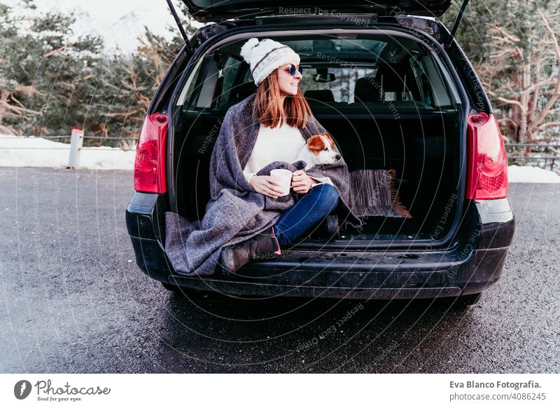 Frau und niedlichen Jack Russell Hund genießen im Freien am Berg in das Auto. Reisen Konzept. Wintersaison PKW Schnee Berge u. Gebirge reisen Lifestyle Fernweh