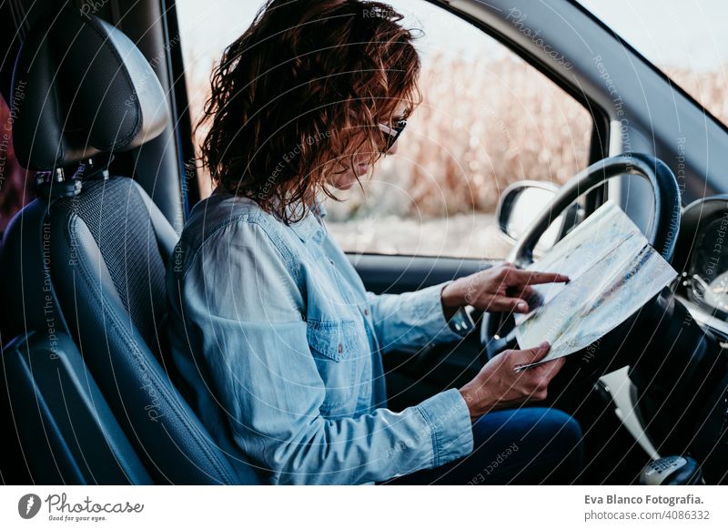 junge schöne Frau lesen eine Karte in einem Auto. Reise-Konzept Landkarte fahren PKW sonnig Sonnenbrille reisen reisend Rad Laufwerk mieten Teilen neu Verkehr
