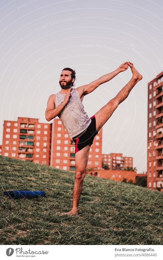 junger Mann in einem Park übt Yoga Sport. Stadt Hintergrund. gesunden Lebensstil. Großstadt Sonnenuntergang Lifestyle Gesundheit Unterlage Sportkleidung