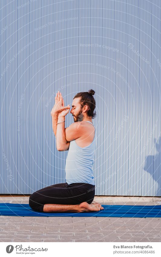 mann in der stadt, der yoga-sport betreibt. blauer hintergrund. gesunde lebensweise Yoga Mann Sport Gesundheit im Freien Großstadt Blauer Hintergrund muskulös