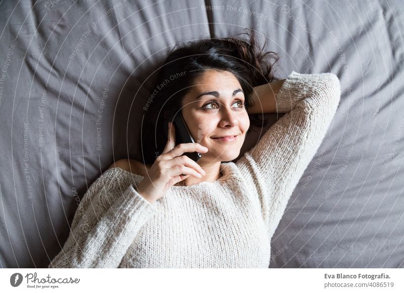 junge Frau, die am Telefon spricht und lächelt Kaffee Lifestyle lässig Internet Business Vernetzung Selfie sozial Bett Haus heimwärts Schlafzimmer Morgen